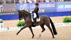 Becky Moody riding Jagerbomb in trot across the diagonal at the London International Horse Show 2024