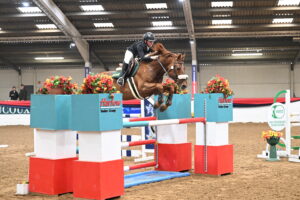 Charlie Barker and Green Grass win the children on horses final at the British Showjumping Spring Championships.
