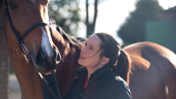 Young woman looking up her horse