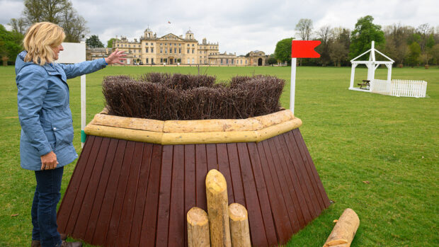 Tina Cook stands in front of a hexagonal brush-topped box at fence 23ab on the 2025 Badminton cross-country course.