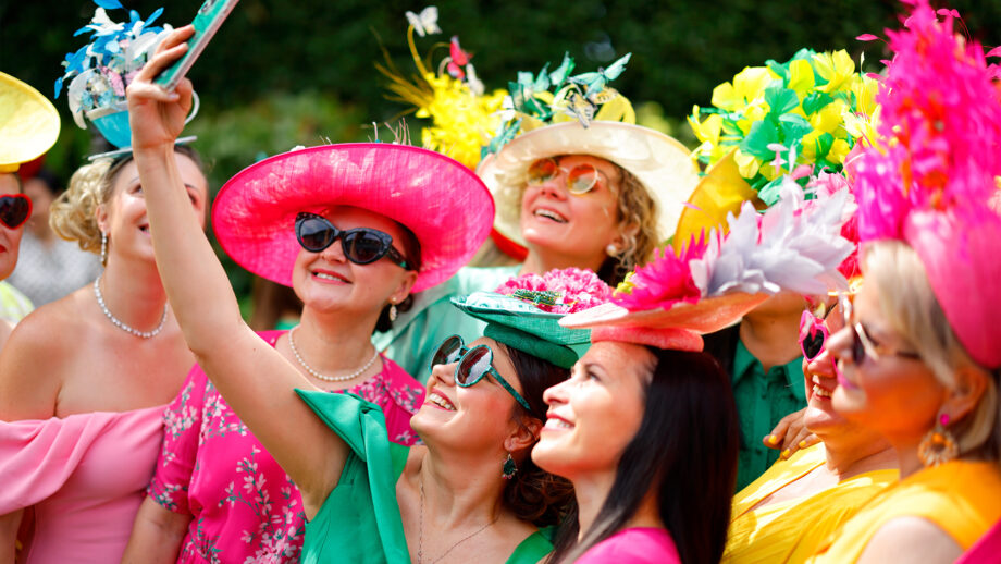 Close up of female racegoers wearing brightly coloured dresses at Royal Ascot