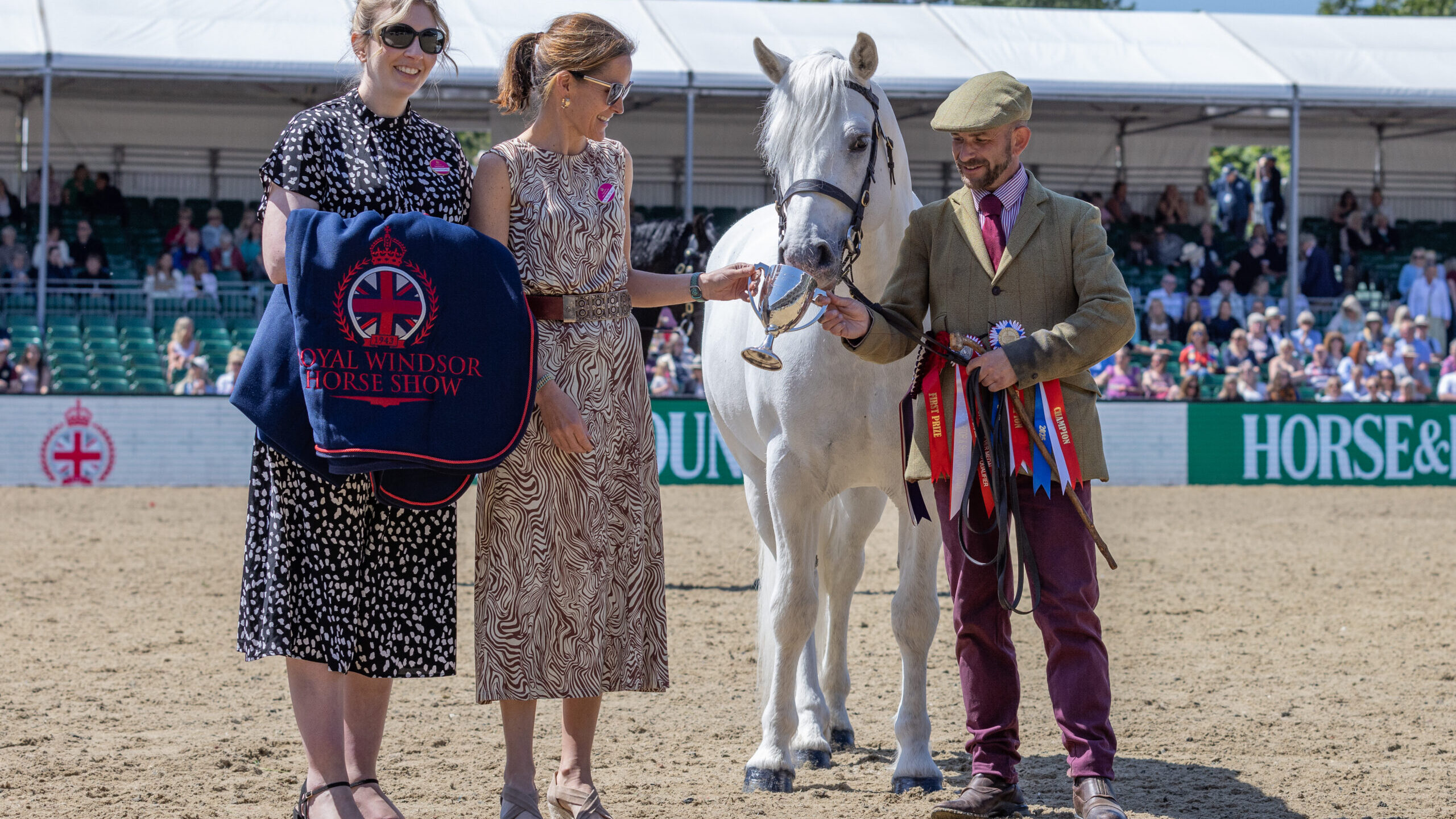 Connemara Clover Hill Magic and handler Jamie Frost are presented with the overall M&M in-hand championship at Royal Windsor Horse Show