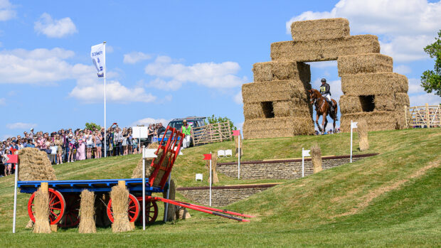 Sammi Birch rides Finduss PFB through the archway of straw bales before tacking the staircase at fence 4