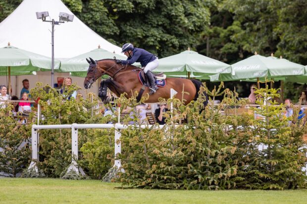 Robert Whitaker and Gentleman VH Veldhof clear the big white oxer at fence two on their way to winning the Al Shira'aa Hickstead Derby 2025.