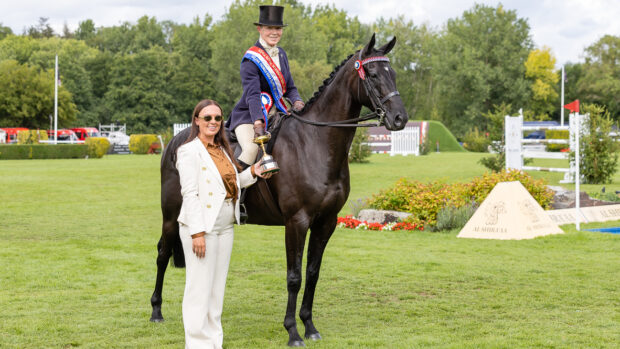 Boston Black Tie ridden by Helen Baker pose for a photo with sponsor Ellena Thomas having stood hack champions at the 2025 Royal International