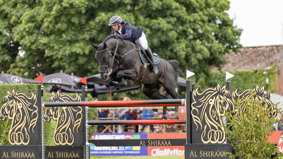 Robert Whitaker and Vermento jump the Al Shira'aa oxer to win the King George V gold cup at Hickstead's Royal International Horse Show