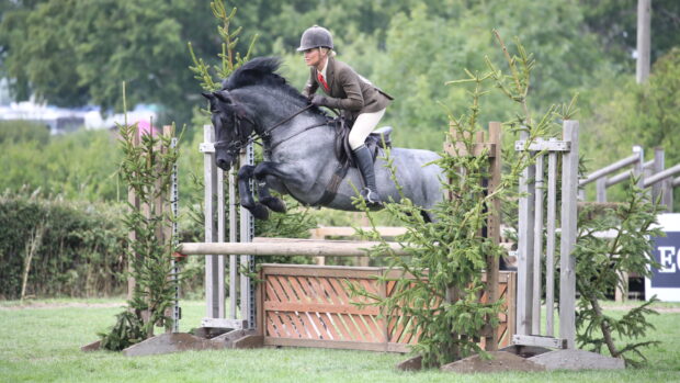 Vikki Smith and roan New Forest pony Lovelyhill Folklore jump to victory in the m&m working hunter pony championship at the 2025 Royal International