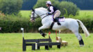 Franchesca jumping cross-country jump, with horse wearing Lemieux MIMsafe Cross Country boots