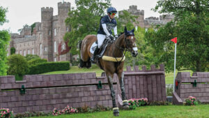 Laura Collett and London 52 clear a castle-shaped cross-country fence with Scone Palace in the background.