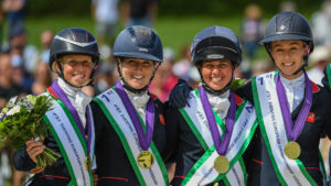 Ros Canter, Laura Collett, Kitty King and Yasmin Ingham celebrate their team gold medals on the podium at the 2023 European Eventing Championships.