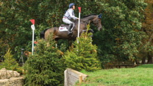 Tom McEwen and JL Dublin jump right to left over a brush cross-country fence with a large open ditch in front at the Blenheim Europeans 2025.