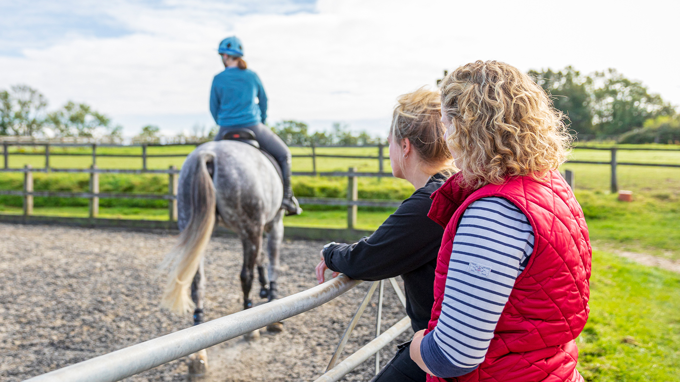Potential buyers observing a new horse under saddle