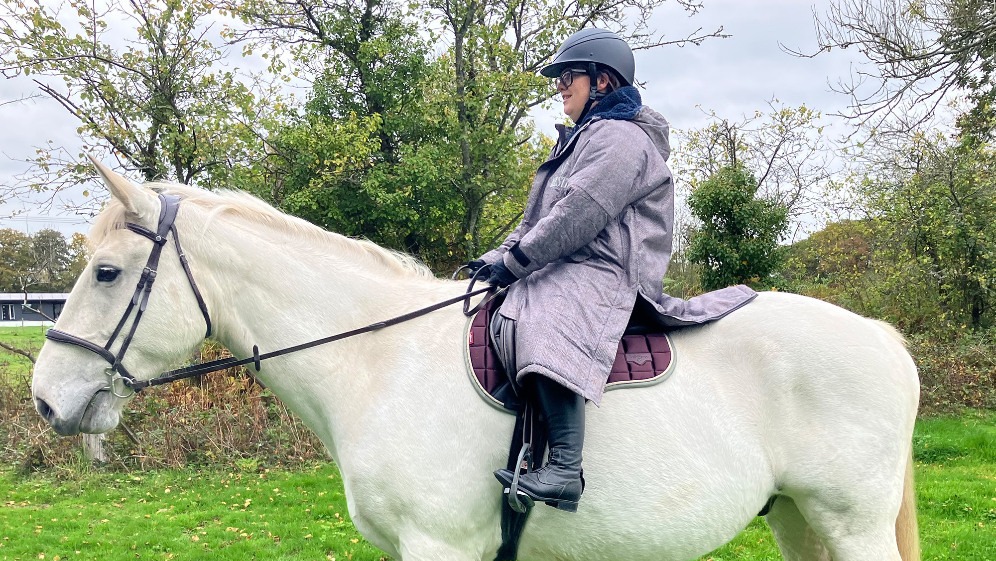 Rider wear Hestt Eco-Ultra Riding robe on a horse, viewed from the side