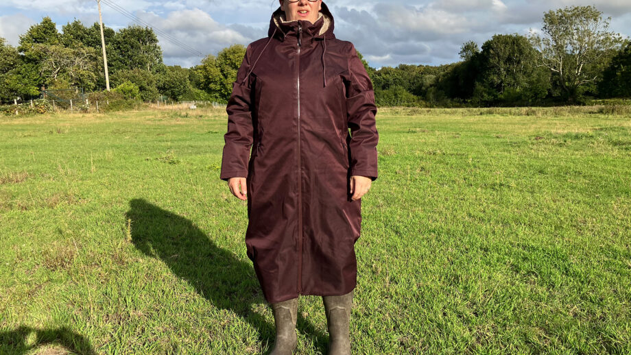 Lady wears LeMieux All Elements Robe in a field, viewed from the front