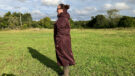 Lady wears LeMieux All Elements Robe in a field, viewed from the side