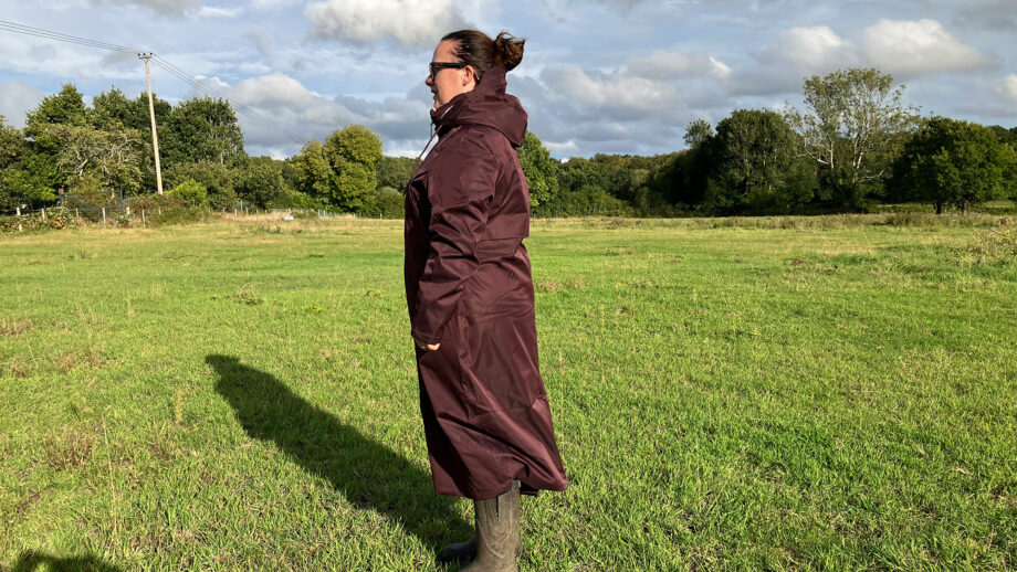Lady wears LeMieux All Elements Robe in a field, viewed from the side