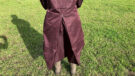 Lady wears LeMieux All Elements Robe in a field, close up of riding vent viewed from the back