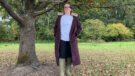 Lady wears LeMieux All Elements Robe standing by a tree unzipped, viewed from the front
