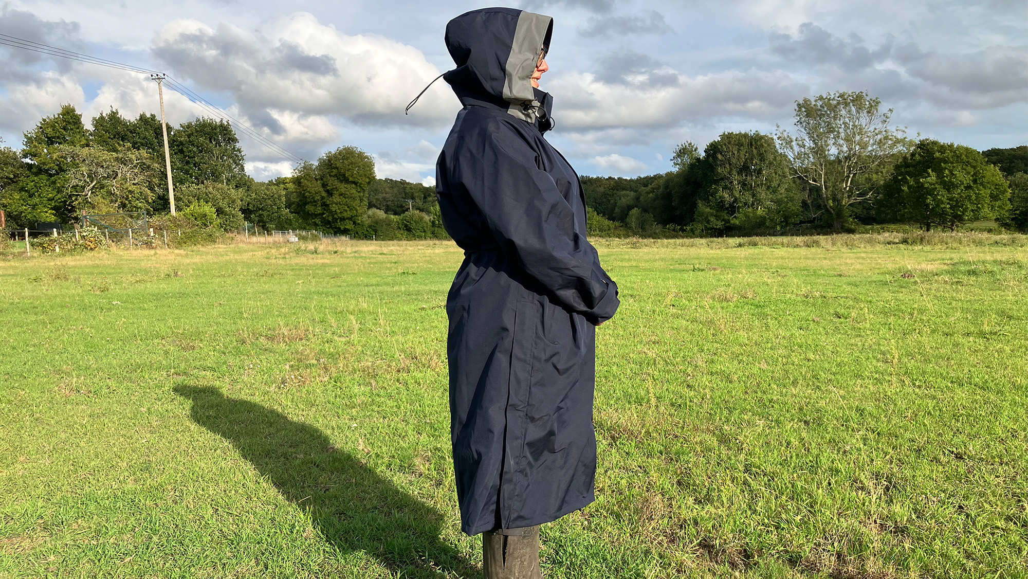 Lady wears Reincoat Lite with the hood up, viewed from the side