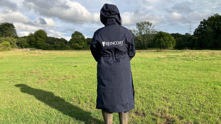 Lady wears Reincoat Lite with the hood up, viewed from the back