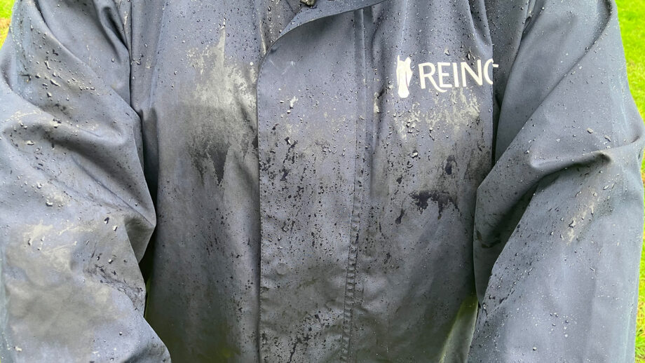 Lady wears Reincoat Lite, viewed from the front showing a close up of rain on material