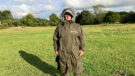 Lady wears Reincoat Pro in a field with hood up, viewed from the front