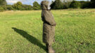 Lady wears Reincoat Pro in a field with hood up, viewed from the side