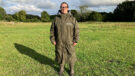 Lady wears Reincoat Pro in a field, viewed from the front