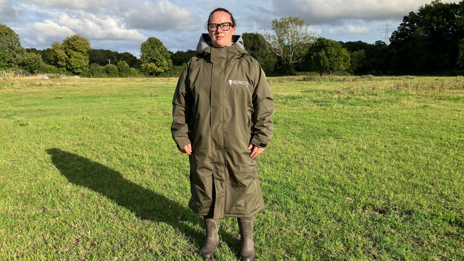 Lady wears Reincoat Pro in a field, viewed from the front