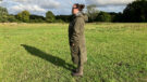 Lady wears Reincoat Pro in a field, viewed from the side