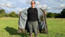 Lady wears Reincoat Pro in a field unzipped showining lining, viewed from the front