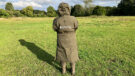 Lady wears Reincoat Pro in a field with hood up, viewed from the back