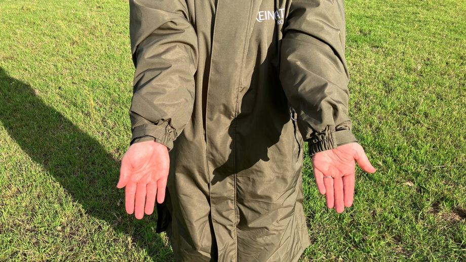 Lady wears Reincoat Pro in a field showing close up of cuffs