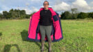 Lady wears Rydale Utility Changing Robe in a field, coat unzipped viewed from the front