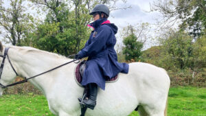 Rider wears Rydale Utility changing robe on horse, viewed from the side