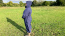 Lady wears Rydale Utility Changing Robe in a field with the hood up, viewed from the side
