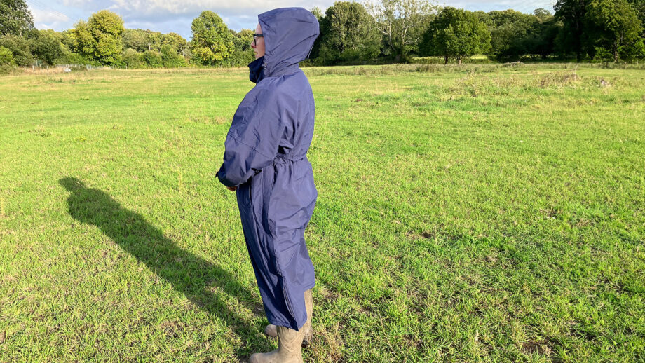 Lady wears Rydale Utility Changing Robe in a field with the hood up, viewed from the side