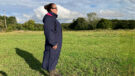Lady wears Rydale Utility Changing Robe in a field, viewed from the side