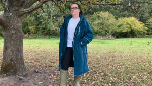 Lady wearing Two Bare Feet Hi-Vis Lightweight Riding Robe unzipped standing by a tree