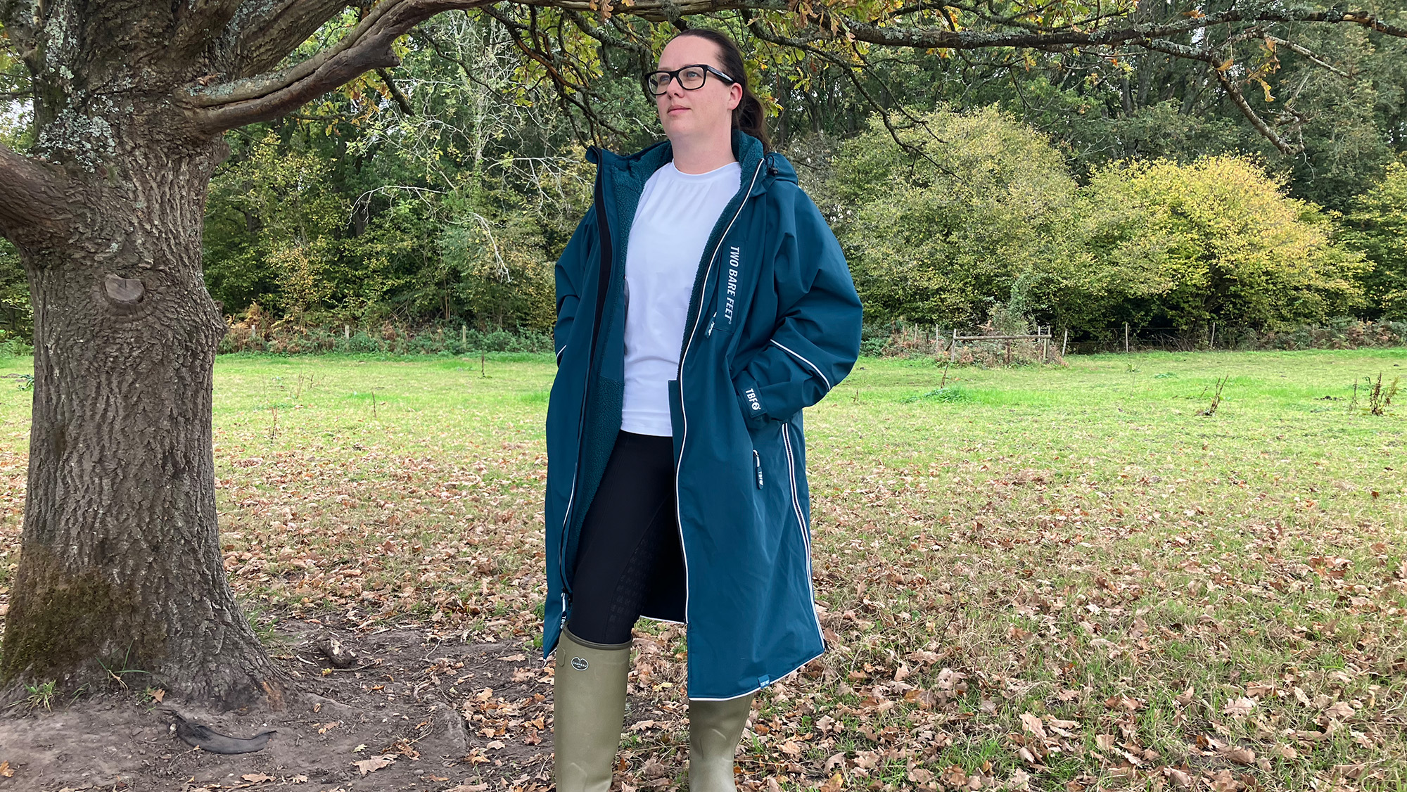 Lady wearing Two Bare Feet Hi-Vis Lightweight Riding Robe unzipped standing by a tree