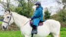 Rider wears Two Bare Feet Hi-Vis Lightweight Riding Robe on a horse, viewed from the side