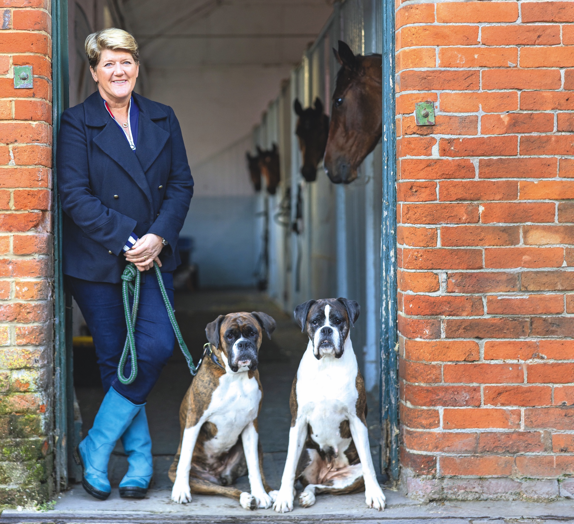 Clare Balding in stable yard with dogs