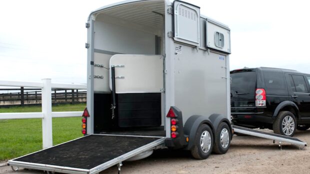 A horse trailer pictured from behind with the ramps down ready for loading.