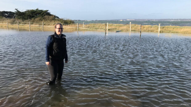 Fran wearing her aigle wellies wading through a high tide flood in her field