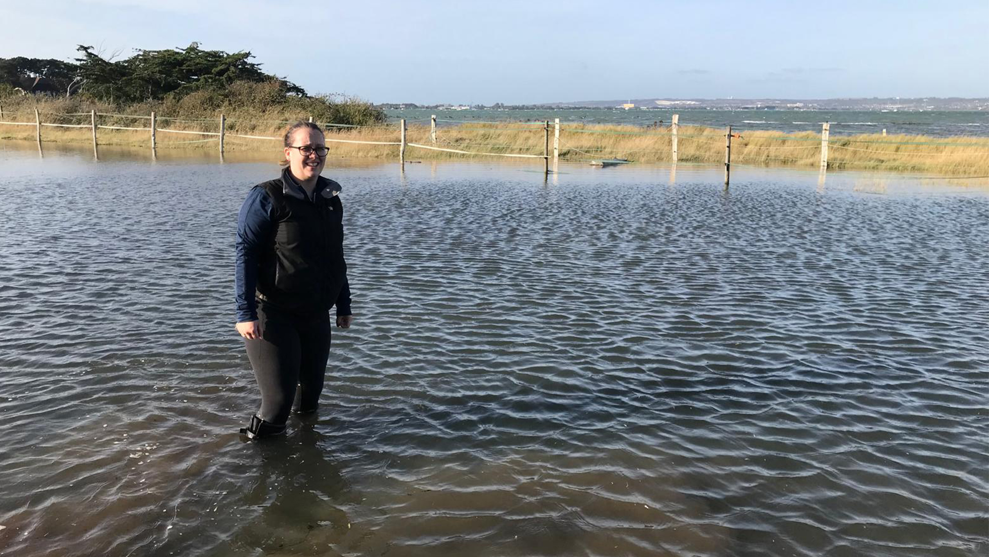 Fran wearing her aigle wellies wading through a high tide flood in her field