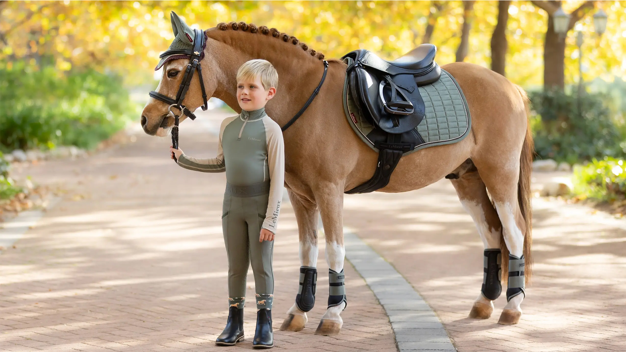 Boy holding his pony wearing Lemeiux matchy matchy in Rosemary 
