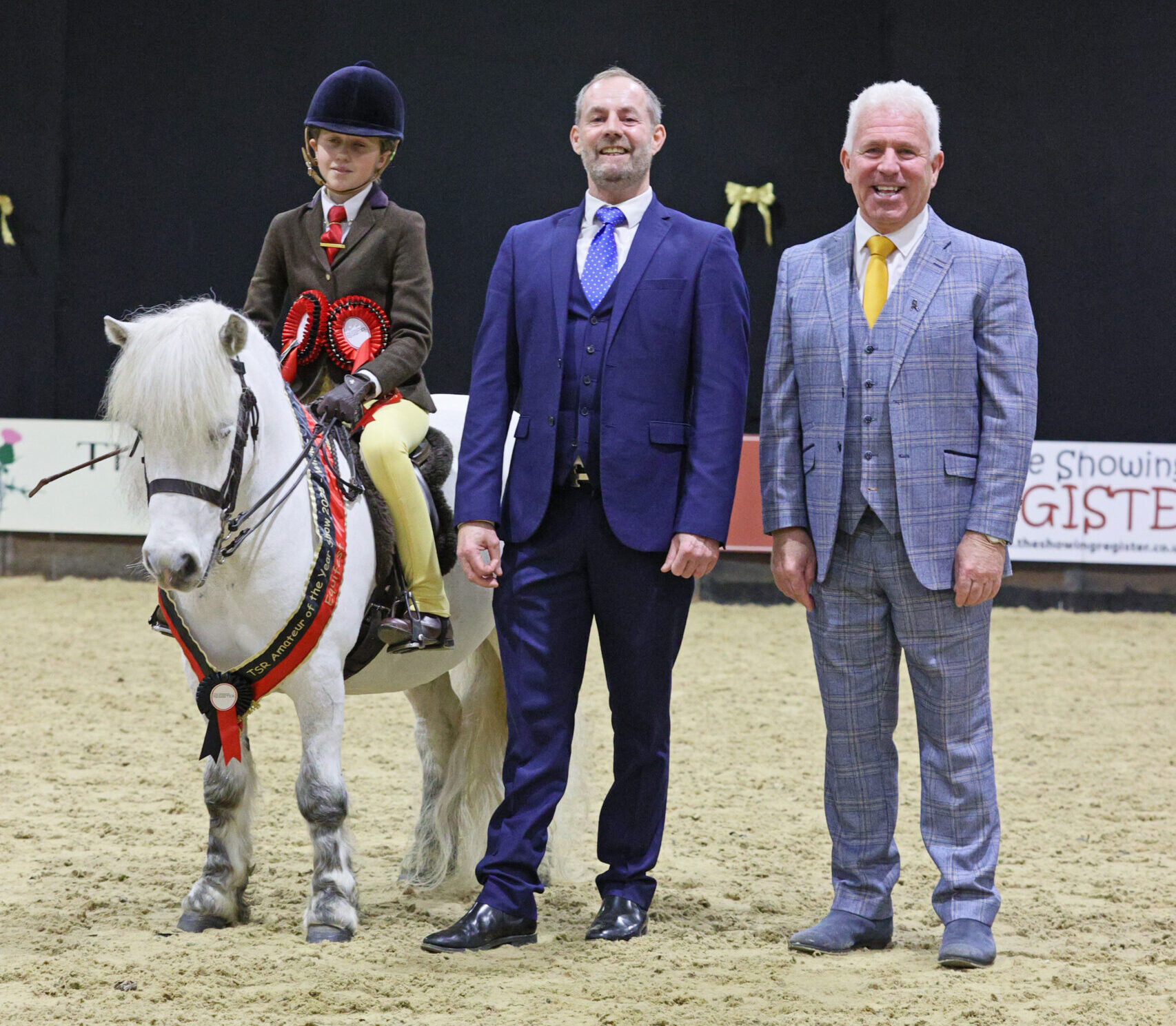 Briar Snowstorm Tillie Goulding stand for a photo with judges Mathew Lawrence and Anthony Perkins having won the M&M small breeds division at the 2025 TSR Amateur of the Year Championship show