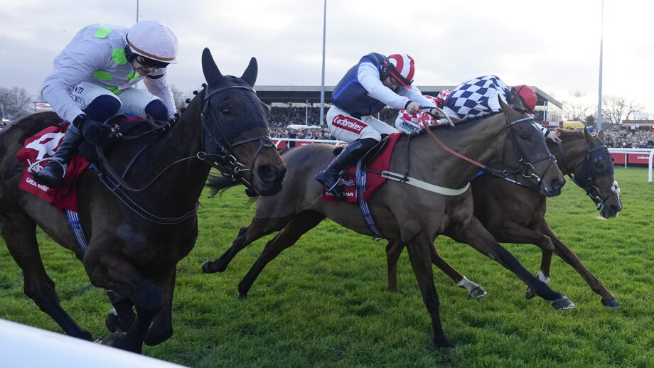 Three racehorses at full gallop in the Ladbrokes King George VI Chase at Kempton Park
