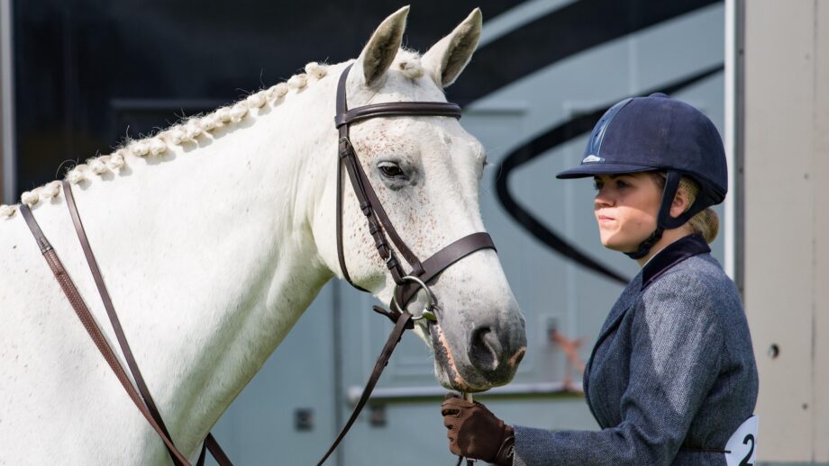 Nervous rider waiting with horse at showjumping competition