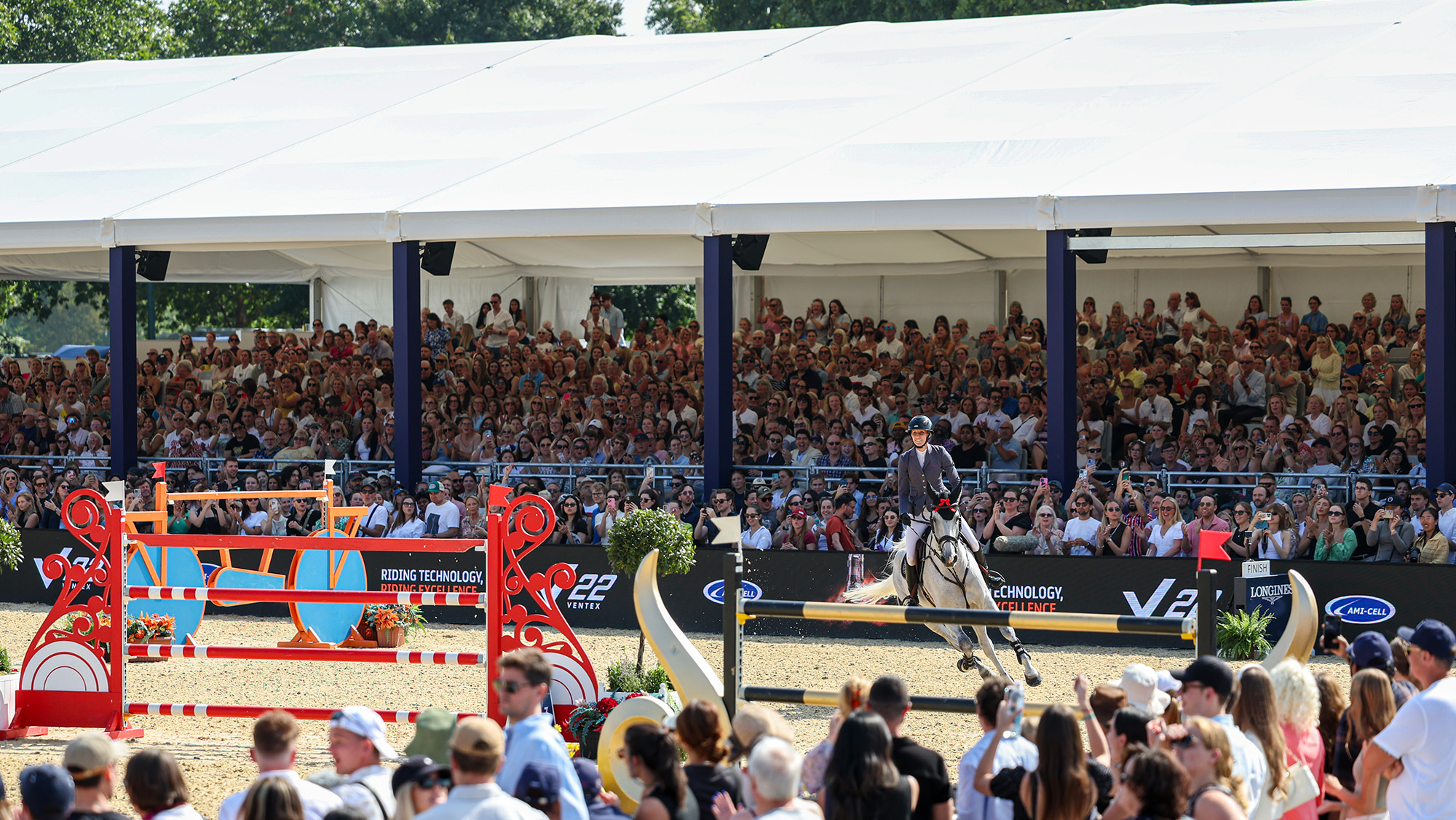 Rider jumping in front of the covered grandstand seating area